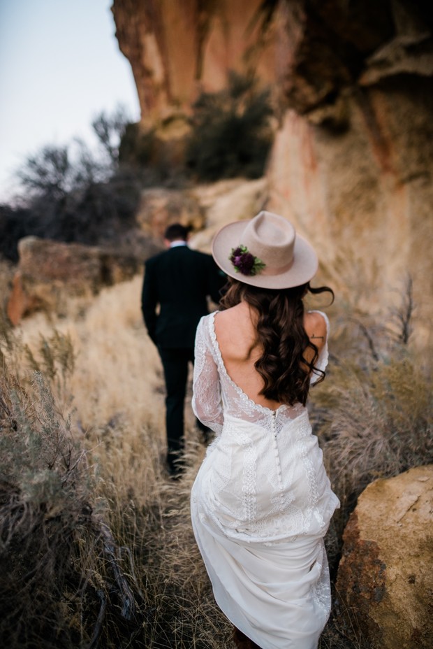 Bride and groom hike up a trail on their wedding day