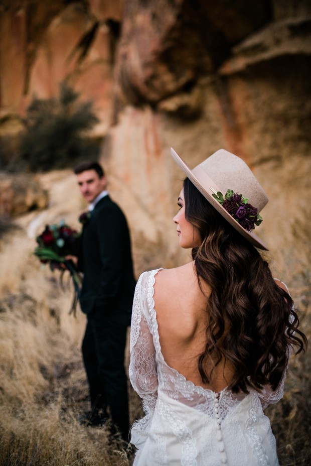 Bride in lace dress and hat with groom in black suit