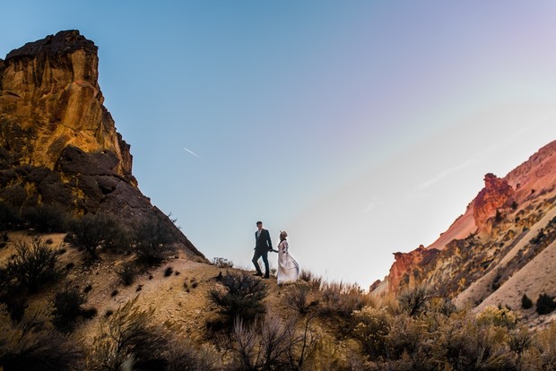Bride and groom hiking on a sunny day in the desert landscape