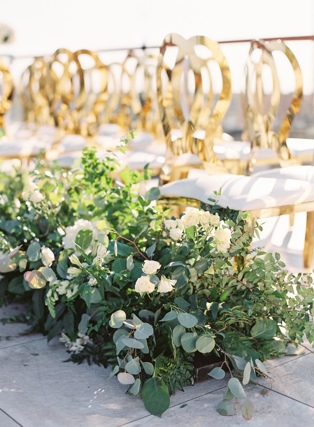 Wedding ceremony with golden chairs and floral decorations