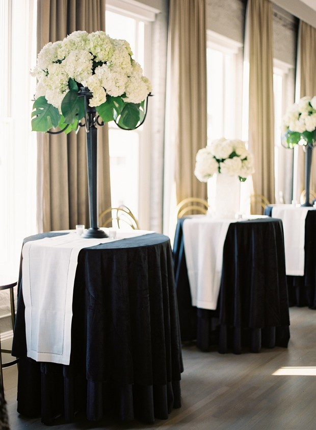 Elegant white flower arrangements on black skirted tables