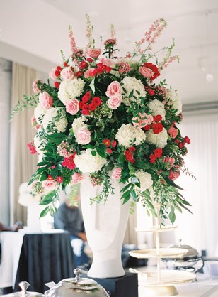 Elegant floral arrangement in a tall white vase for events