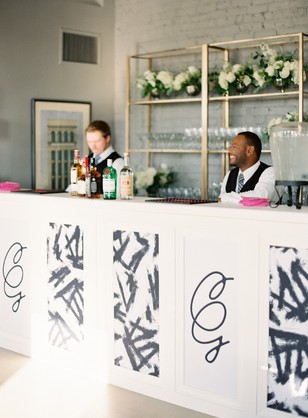 Elegant bar at a wedding with bartenders and white decor