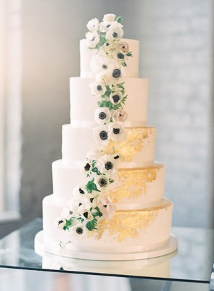 Elegant wedding cake with gold accents and floral cascade