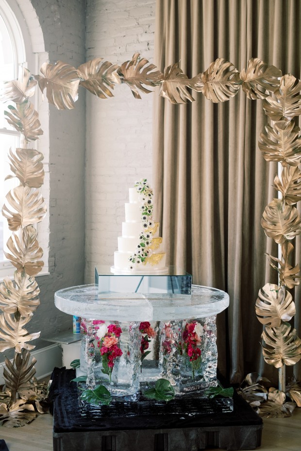 Elegant wedding cake on ice table with gold leaf decor