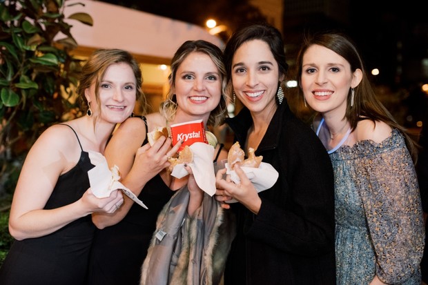 Four smiling women enjoy Krystal burgers and snacks together