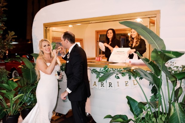 Bride and groom enjoying a snack at a wedding with food truck