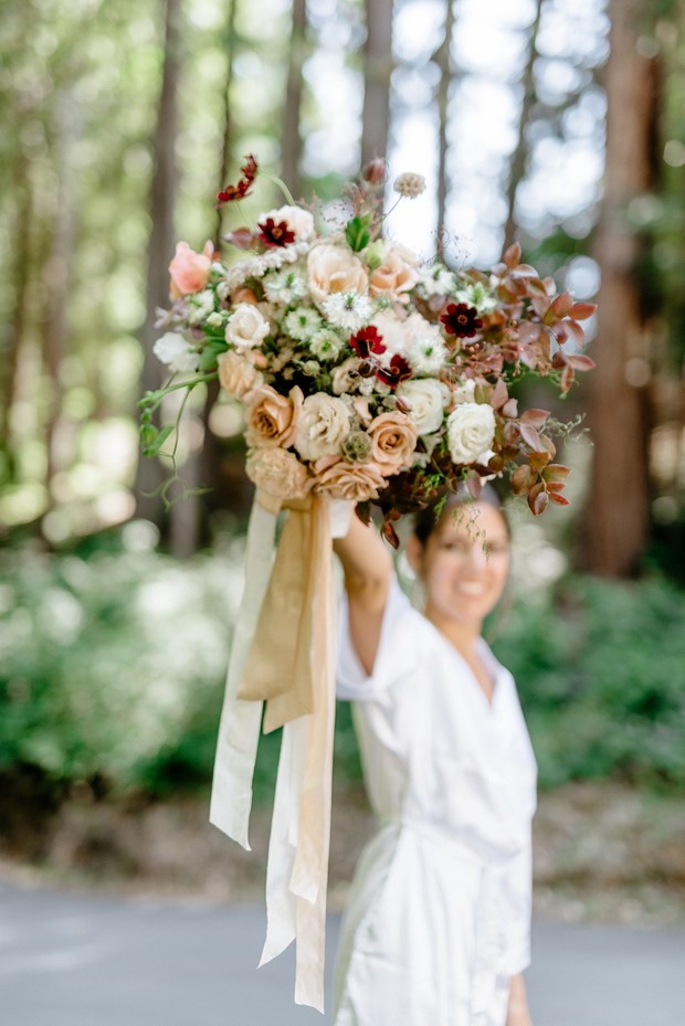 Bride holding a beautiful bouquet of colorful flowers, happy wedding day