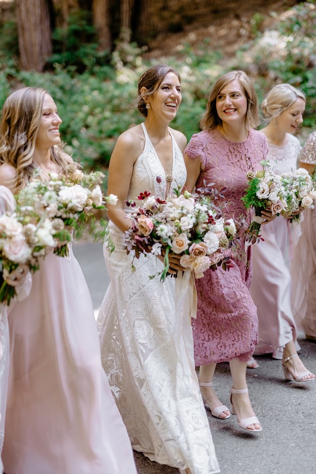 Happy bride and bridesmaids with flowers and smiles