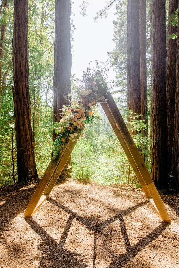 Wooden wedding arch adorned with flowers in a redwood forest