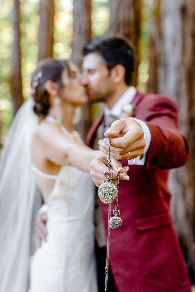 Romantic wedding kiss with vintage pocket watches detail