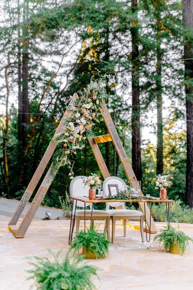 Rustic wedding setup with floral arch and forest background