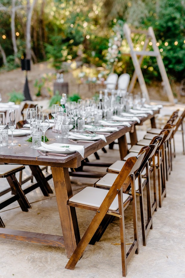 Elegant outdoor wedding reception table setting with chairs