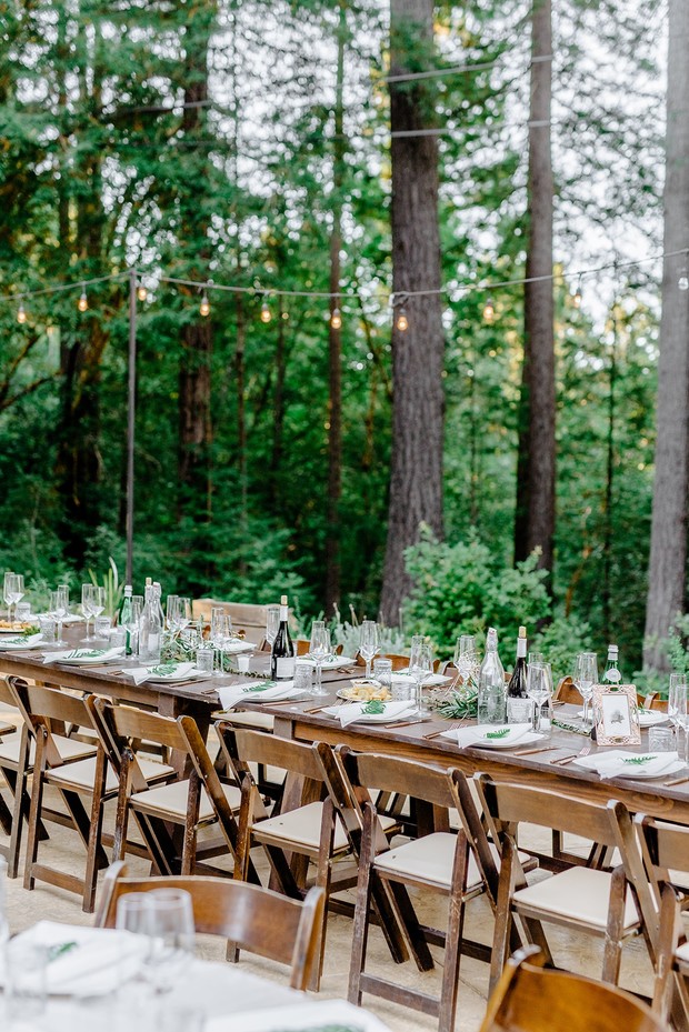Outdoor wedding reception table set in a forest setting