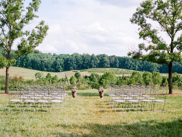 Outdoor wedding setup with chairs overlooking vineyard