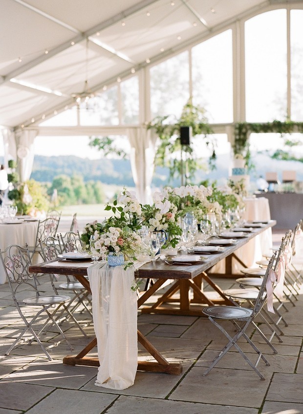 Elegant wedding table setting under a tent with flowers