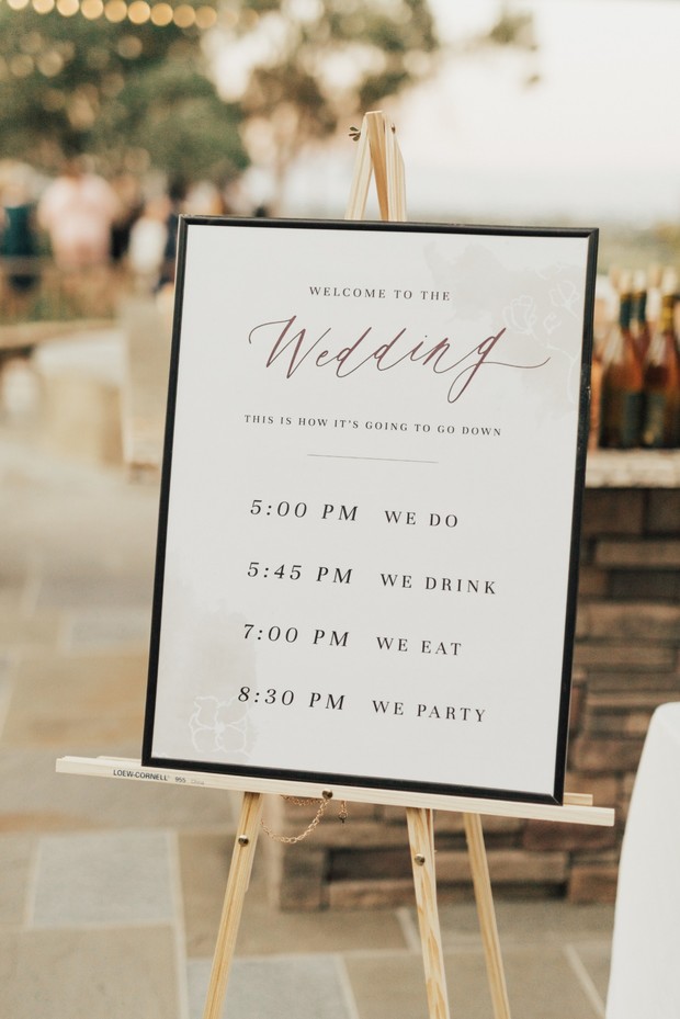 Wedding sign with timeline on wooden easel outdoors