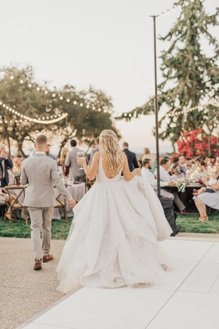 Bride and groom walk down aisle at outdoor wedding reception