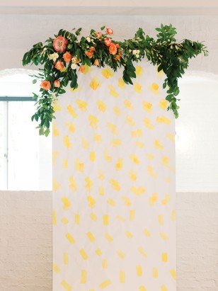Floral garland above a white wall with yellow spots