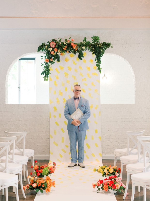 Man in a suit standing at wedding altar with flowers