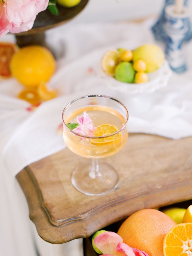 Citrus cocktail on a wooden table with fruits flowers