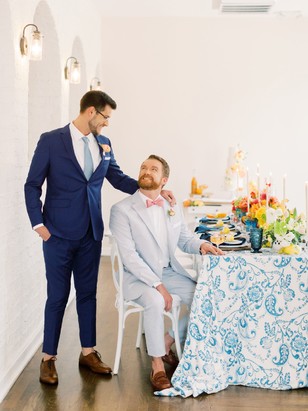 Two grooms look at each other lovingly at wedding reception