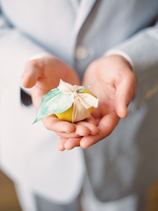 A person holding a wrapped lemon, a natural, handmade gift