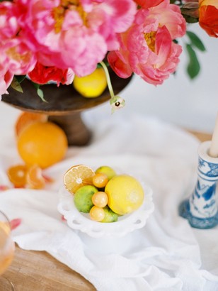 Bright floral arrangement with citrus fruit and table setting