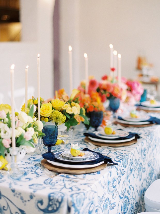 Elegant table setting with flowers, candles, and blue patterned decor