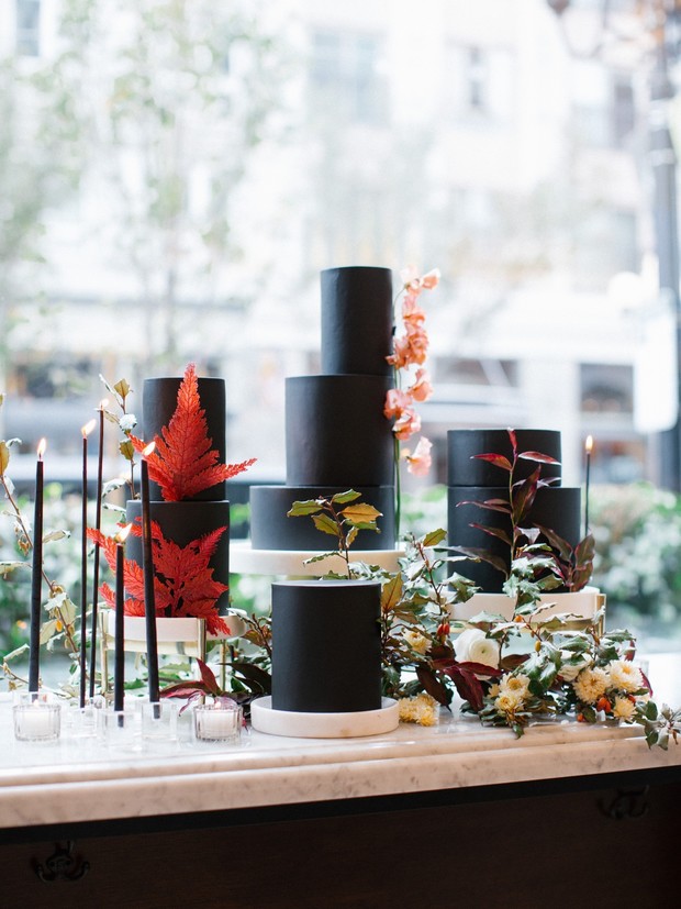 Elegant black wedding cake with floral and candle decor