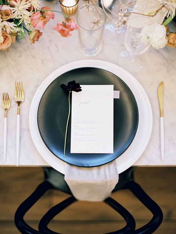 Elegant place setting with black plate and menu card