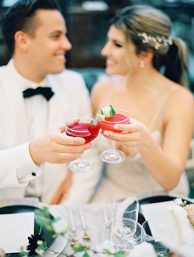 Newlyweds toasting with cocktails at a wedding reception celebration