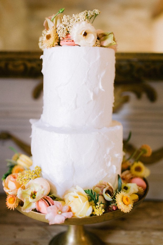 simple white wedding cake with flowers and macarons