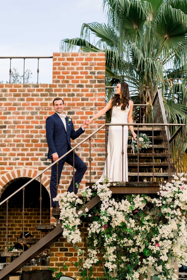 Bride and groom ascending brick stairs, hand in hand