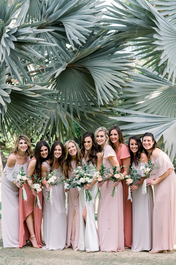 Bridesmaids pose with bouquets in a tropical, natural setting