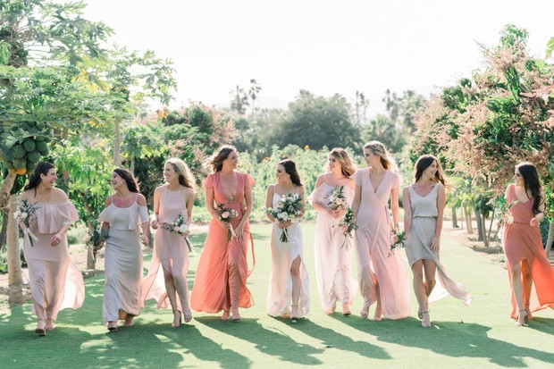 Bridesmaids walking on a sunny day with bouquets and pastel dresses