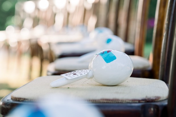 White wedding favors on chairs await guests at the ceremony