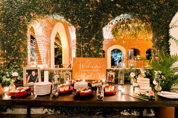 Wedding reception table with cake, cupcakes, and welcome sign
