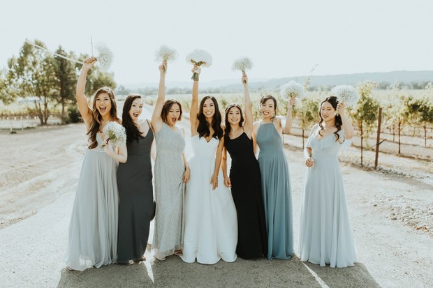 Bride and bridesmaids celebrating with bouquets outdoors