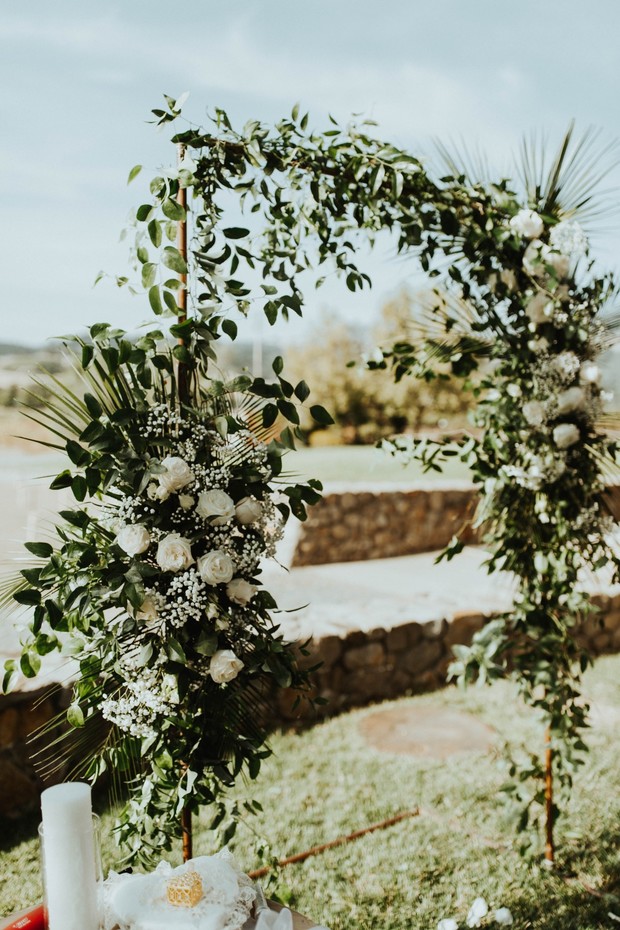 Wedding arch adorned with lush greenery and white flowers