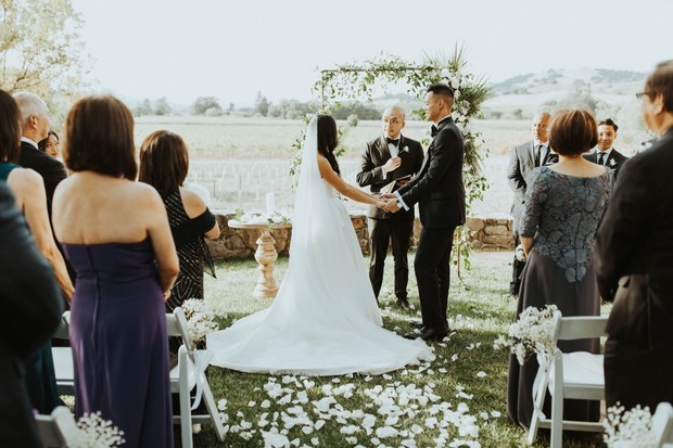 Outdoor wedding ceremony with bride and groom exchanging vows