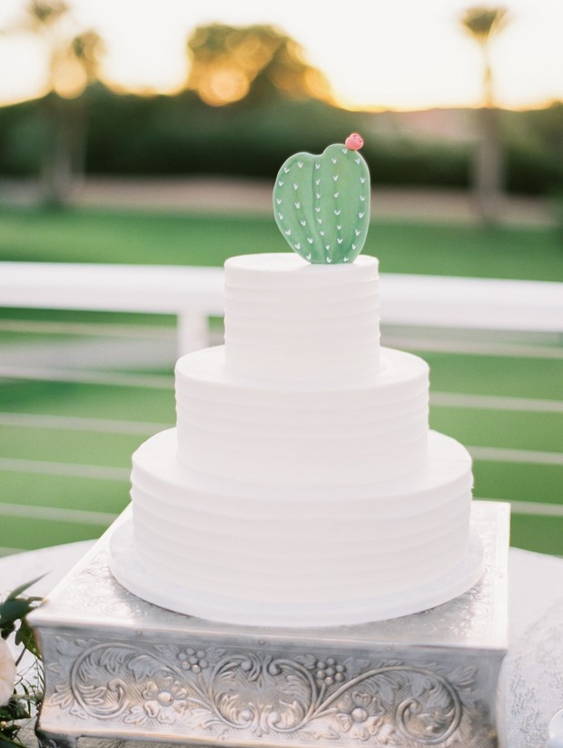 white wedding cake with cactus topper