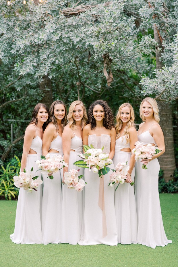 Smiling bridesmaids bride white dresses pink bouquets outdoors