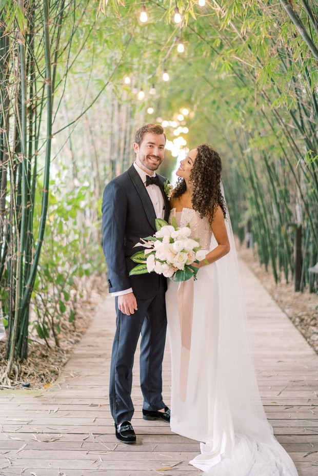 Happy wedding couple smiling in bamboo path setting