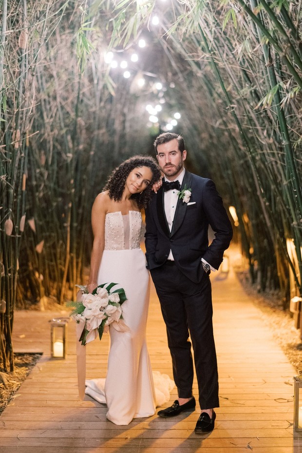 Elegant couple posing for wedding photos in bamboo tunnel