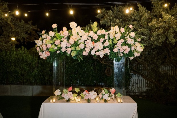Floral arrangement with soft pink roses and candles at night