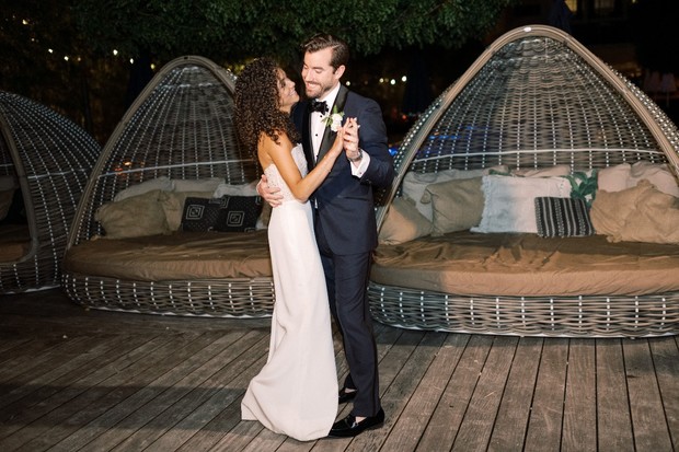 Couple dancing at wedding reception in front of decorative lounges