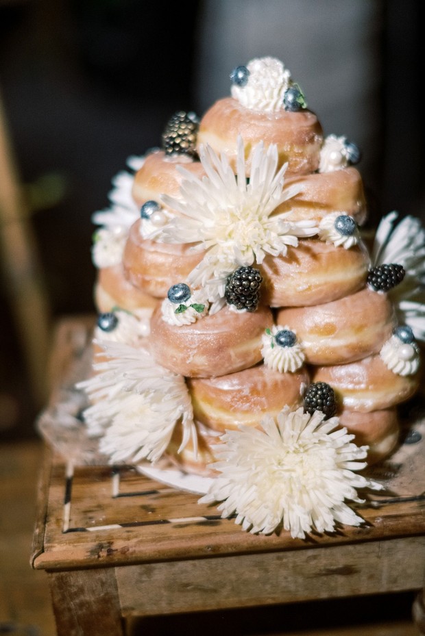 Delicious donut cake decorated with flowers and berries on display