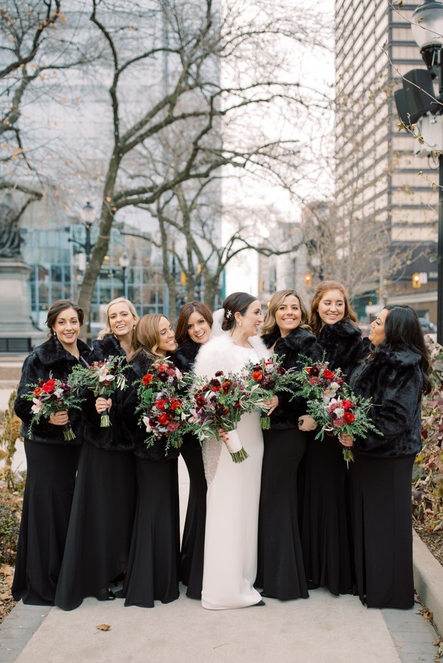 bridesmaids in black dresses with faux fur jackets