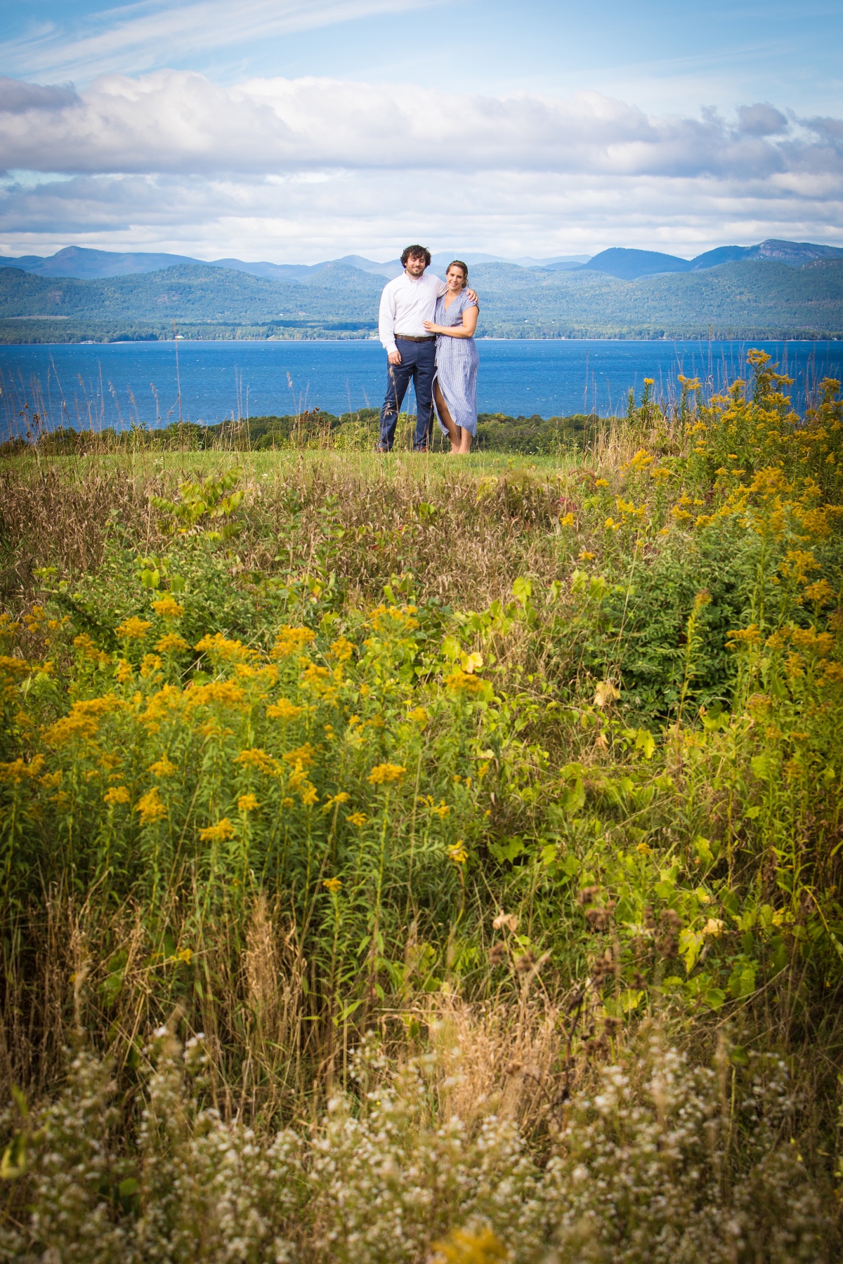 Couple embracing with lake and mountains in the background